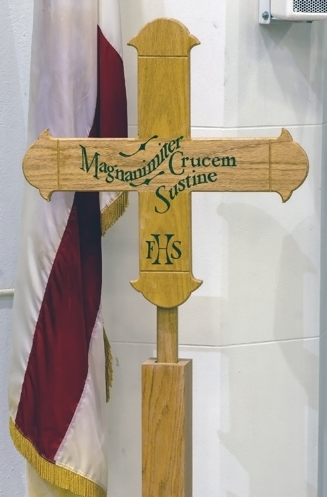 A wooden cross with a flag in the background