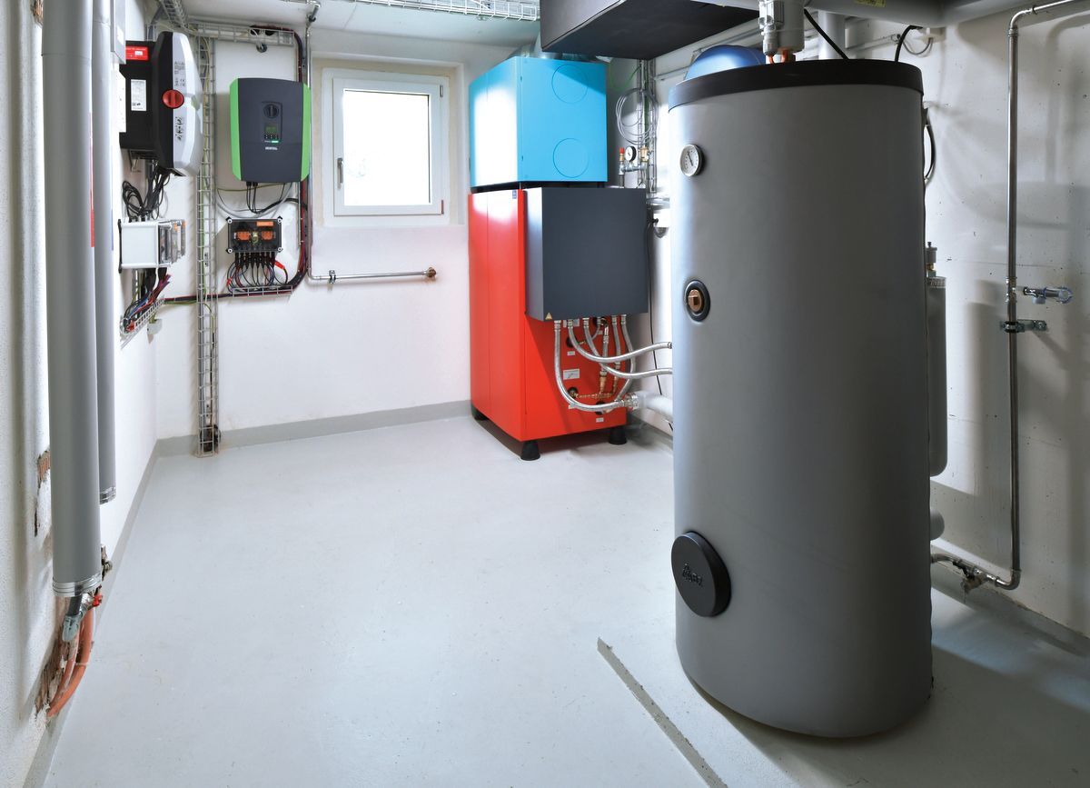 Technikraum im Kellergeschoss mit Warmwasserbereiter, Heizkessel und elektrischen Komponenten.