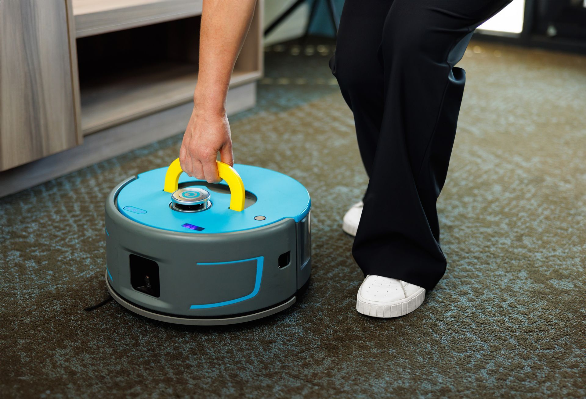 Blue and gray robotic vacuum cleaner with a yellow design on a white background.