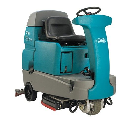 Turquoise and gray industrial floor scrubber with a seat and steering wheel.