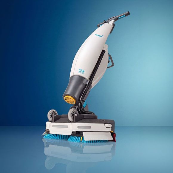 White and blue floor cleaning machine with handle, brushes, and wheels.