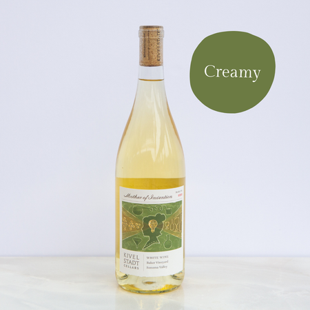 A bottle of white wine with a green circle that says creamy
