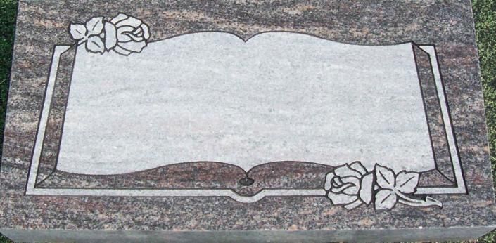 Blank white memorial plaque with floral decorations on a gray stone background