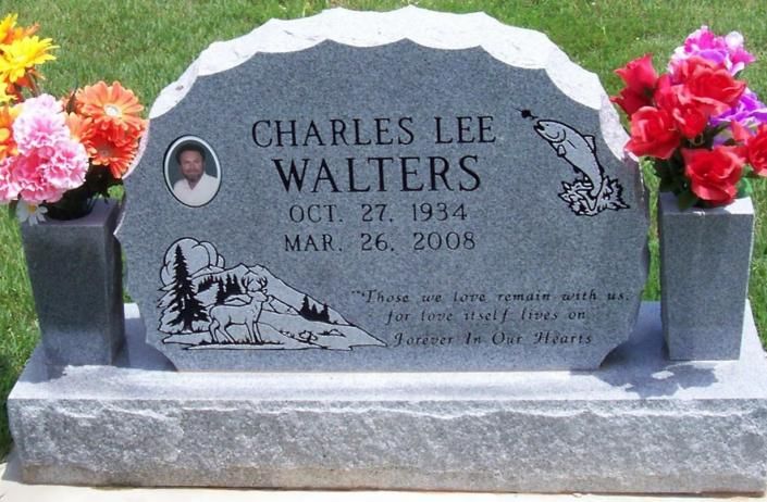 Gray gravestone for Charles Lee Walters with flowers on both sides