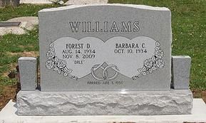 Gray gravestone engraved “WILLIAMS” with floral carvings in a cemetery