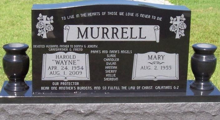 Black Murrell gravestone with white engraved plaques and two black vases on a cemetery plot