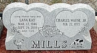 Gray double headstone engraved “MILLS” with two heart-shaped plaques and names/dates for LANA KAY and CHARLES WAYNE JR.