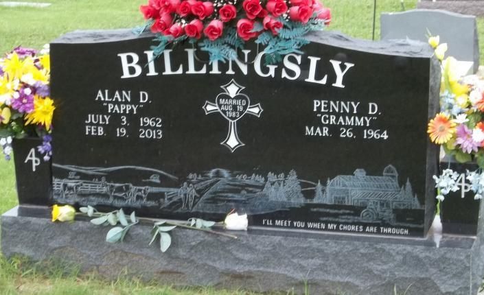 Black BILLINGSLY gravestone with red flowers and engraved names in a cemetery