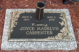 Gravestone for Joyce Madelyn Carpenter with vase, black plaque, and engraved dates on a marble base