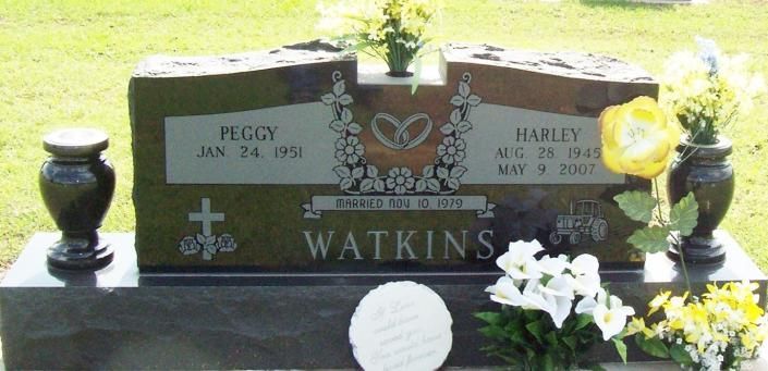 Granite grave marker with flower vase, engraved Watkins and names Peggy and Harley, surrounded by flowers