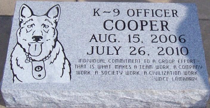 Memorial plaque for K-9 Officer Cooper with dog portrait and dates Aug. 15, 2006–July 26, 2010.