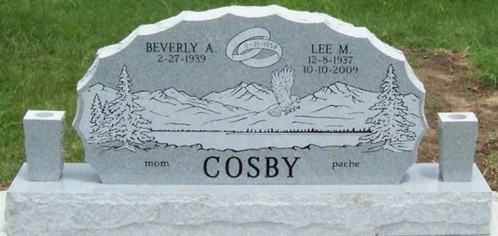 Gray gravestone engraved with a mountain scene and the name “COSBY” in a cemetery