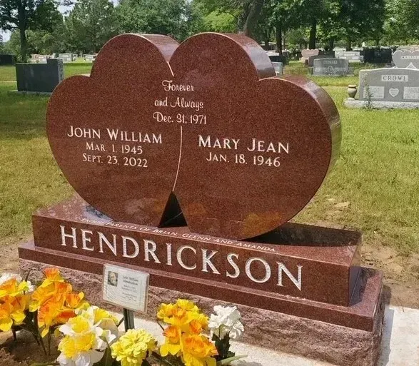 Hendrickson family gravestone with heart-shaped red stone and flowers in a cemetery