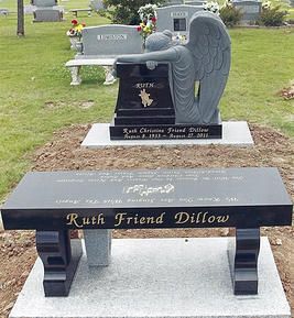 Black granite angel memorial bench with gold lettering in a cemetery, engraved 