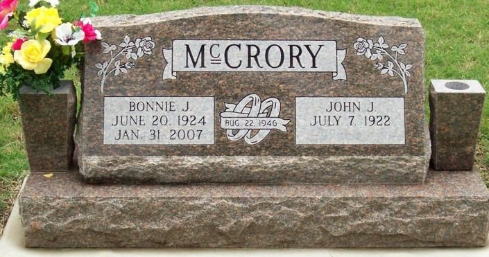McCrory gravestone with engraved plaques and flowers on the left, set on a stone base.
