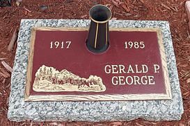 Memorial plaque with a vase holder, engraved “1917,” “1985,” and “GERALD P. GEORGE” on a granite base