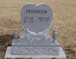 Gray granite double gravestone with “HENDERSON” and two names in a cemetery
