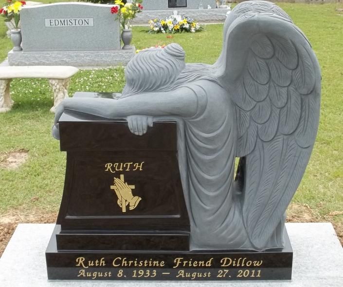 Gray angel gravestone with folded wings in a cemetery, memorial plaque reading “Rush Christine Friend Dills.”