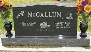McCallum black granite grave marker with floral tributes and engraved names on a cemetery plot