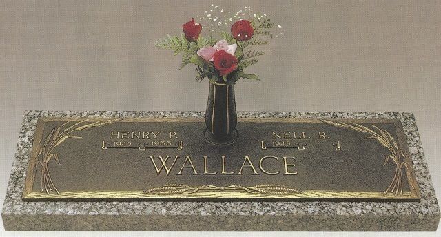 Gravestone with the name Wallace and a small vase of red and white flowers on top