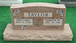 Taylor family gravestone with two name plaques in a cemetery, beige stone on grass
