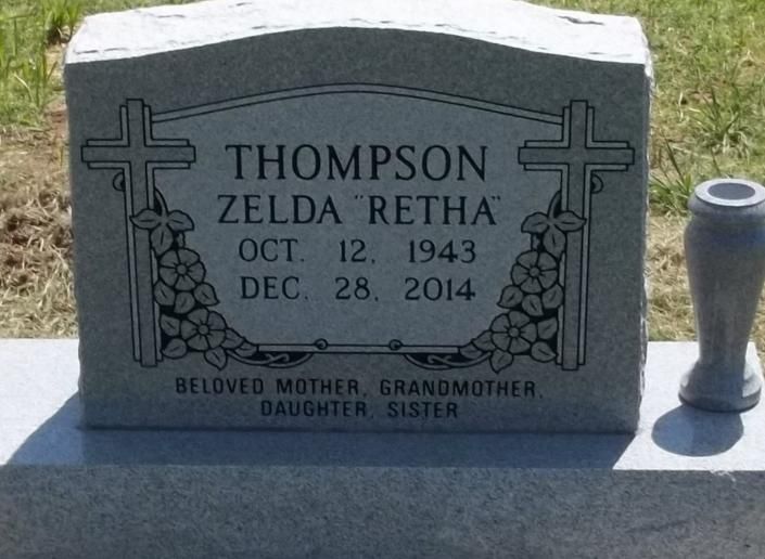 Gray gravestone for Zelda Retha Thompson with cross engravings in a cemetery