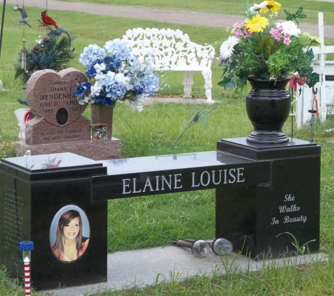 Memorial bench and headstone with flowers in a cemetery, engraved with “ELAINE LOUISE”