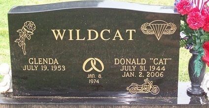 Black granite memorial stone with gold lettering for Wildcat, Glenda, and Donald “Cat” in a cemetery