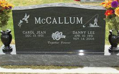 Black granite McCallum cemetery headstone with engraved names, dates, and floral decorations.