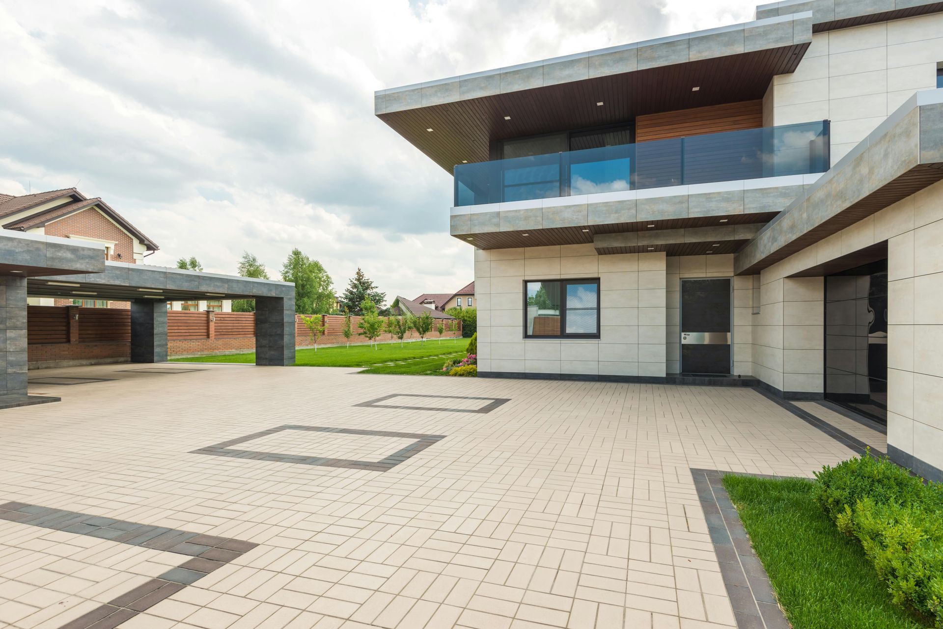 A large modern house with a large driveway in front of it.