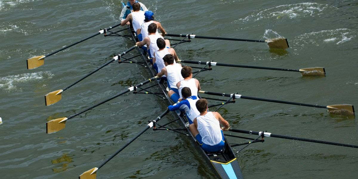 Eight-man rowing crew on a skull pulling together

