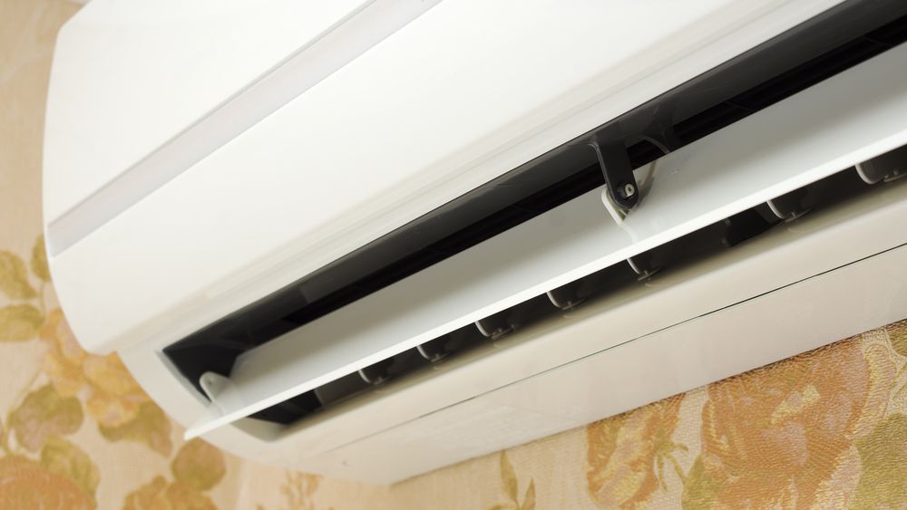 Wall-mounted White Air Conditioner on a Patterned Wall, Shown With the Vent Open — Alpine Refrigeration & Air Conditioning Pty Ltd in Shellharbour, NSW
