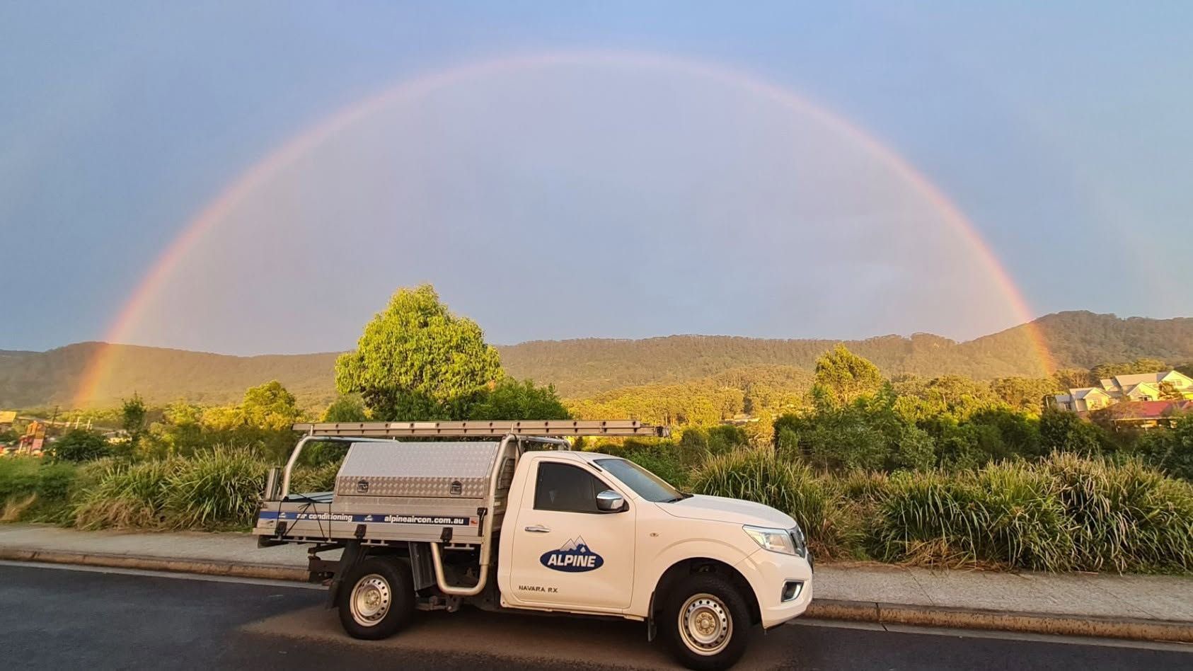 White Pickup Truck on A Road Under a Rainbow — Alpine Refrigeration & Air Conditioning Pty Ltd in Wollongong, NSW