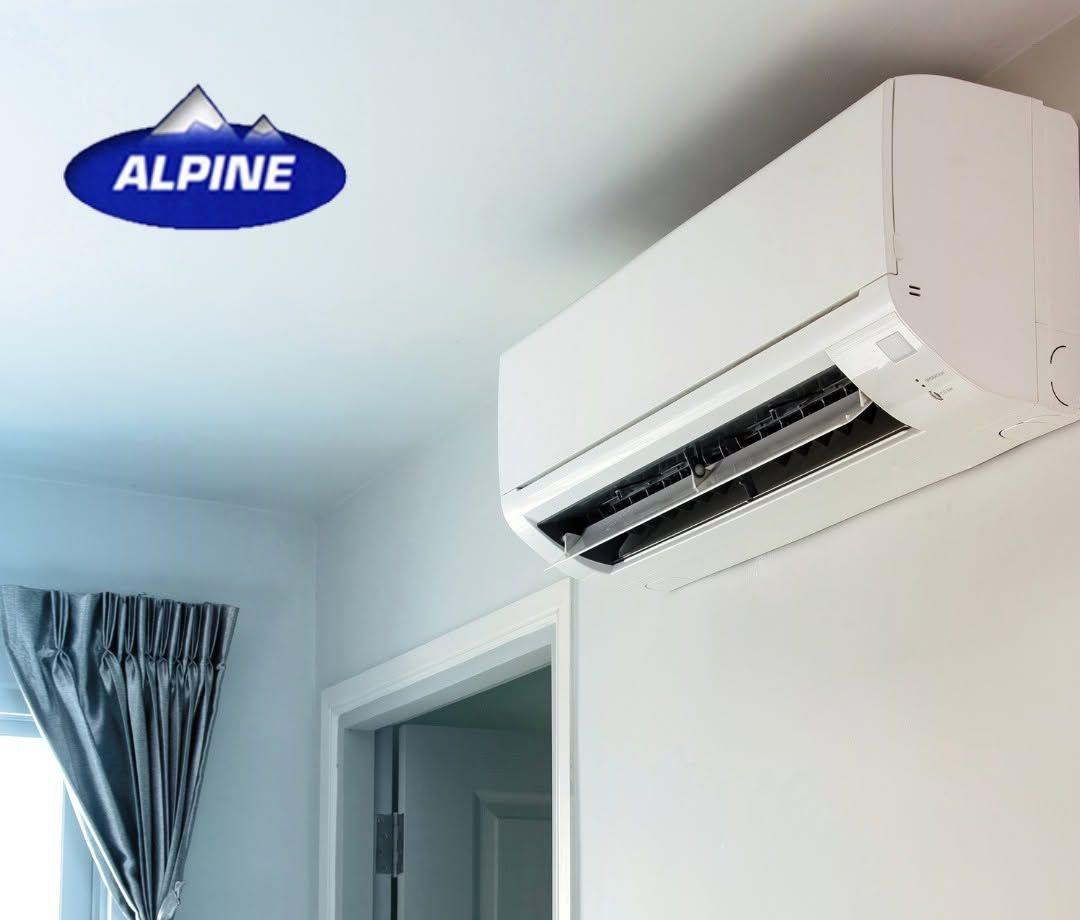 White Wall-Mounted Air Conditioner Above a Doorway in A Light Blue Room — Alpine Refrigeration & Air Conditioning Pty Ltd in Wollongong, NSW