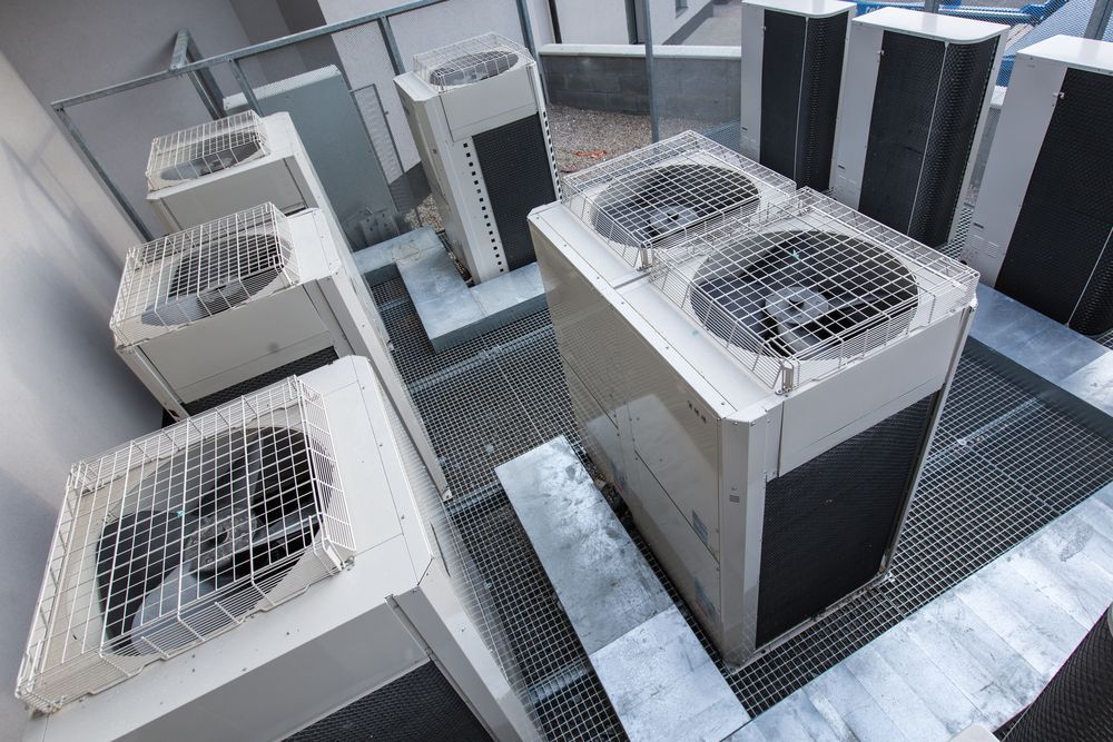 Outdoor HVAC Units With Metal Grates and Fans Arranged on a Rooftop Platform — Alpine Refrigeration & Air Conditioning Pty Ltd in Corrimal, NSW