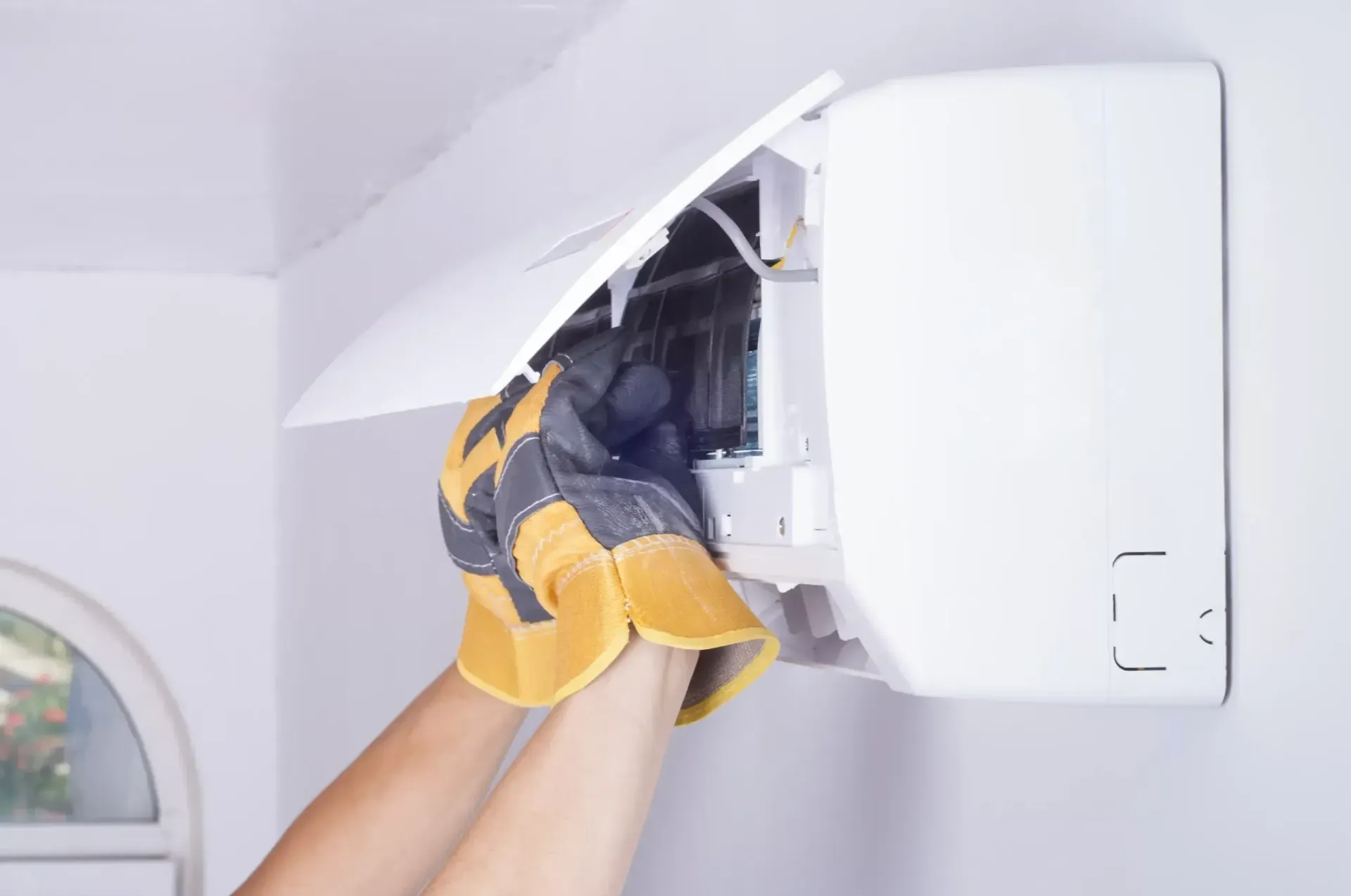 Gloved Hands Repairing Air Conditioner — Alpine Refrigeration & Air Conditioning Pty Ltd in Wollongong, NSW