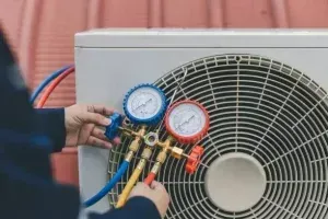 Technician Connects Gauges To An Air Conditioning Unit For Maintenance — Alpine Refrigeration & Air Conditioning in Wollongong, NSW Technician Connects Gauges To An Air Conditioning Unit For Maintenance — Alpine Refrigeration & Air Conditioning in Wollongong, NSW