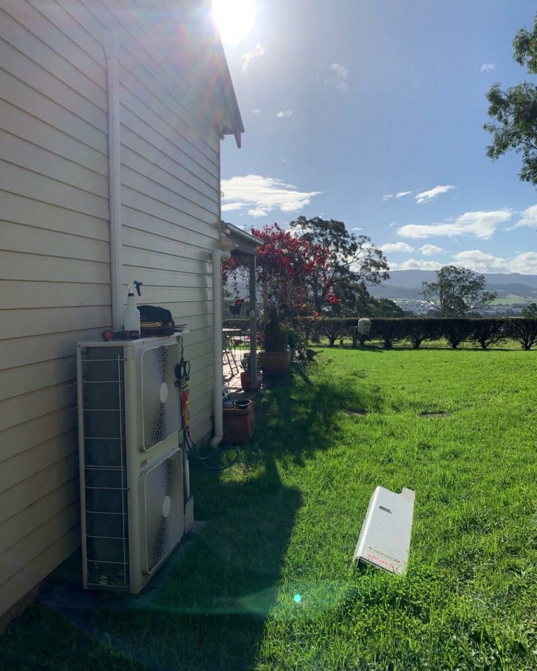 Sunlit Yard Beside a White House — Alpine Refrigeration & Air Conditioning Pty Ltd in Wollongong, NSW