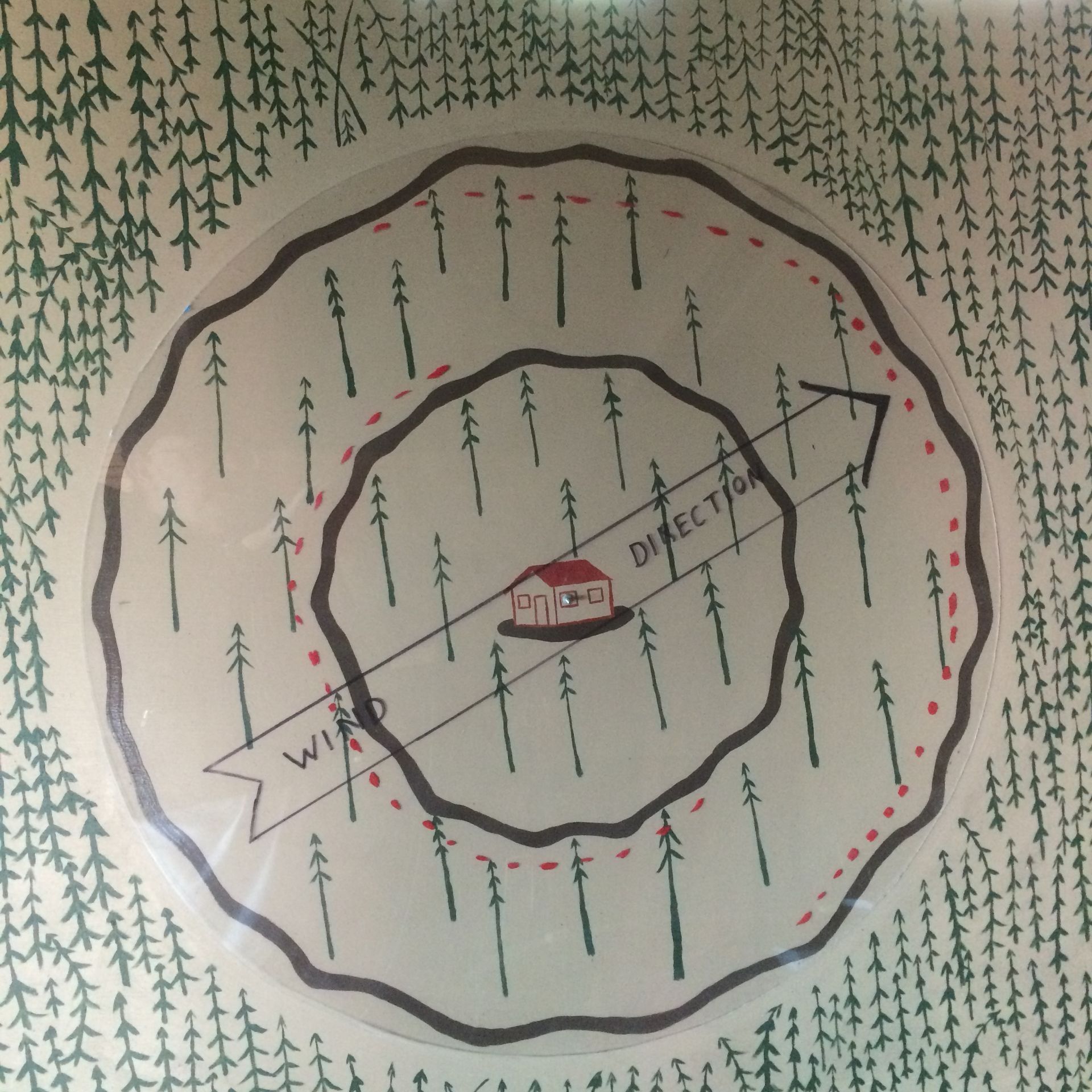 Hand-drawn map with concentric roads around a central red house in a forest, labeled Wisconsin and Minnesota.
