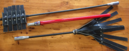 Two telescoping grabbers with red and silver handles and black clawed ends on a wooden floor
