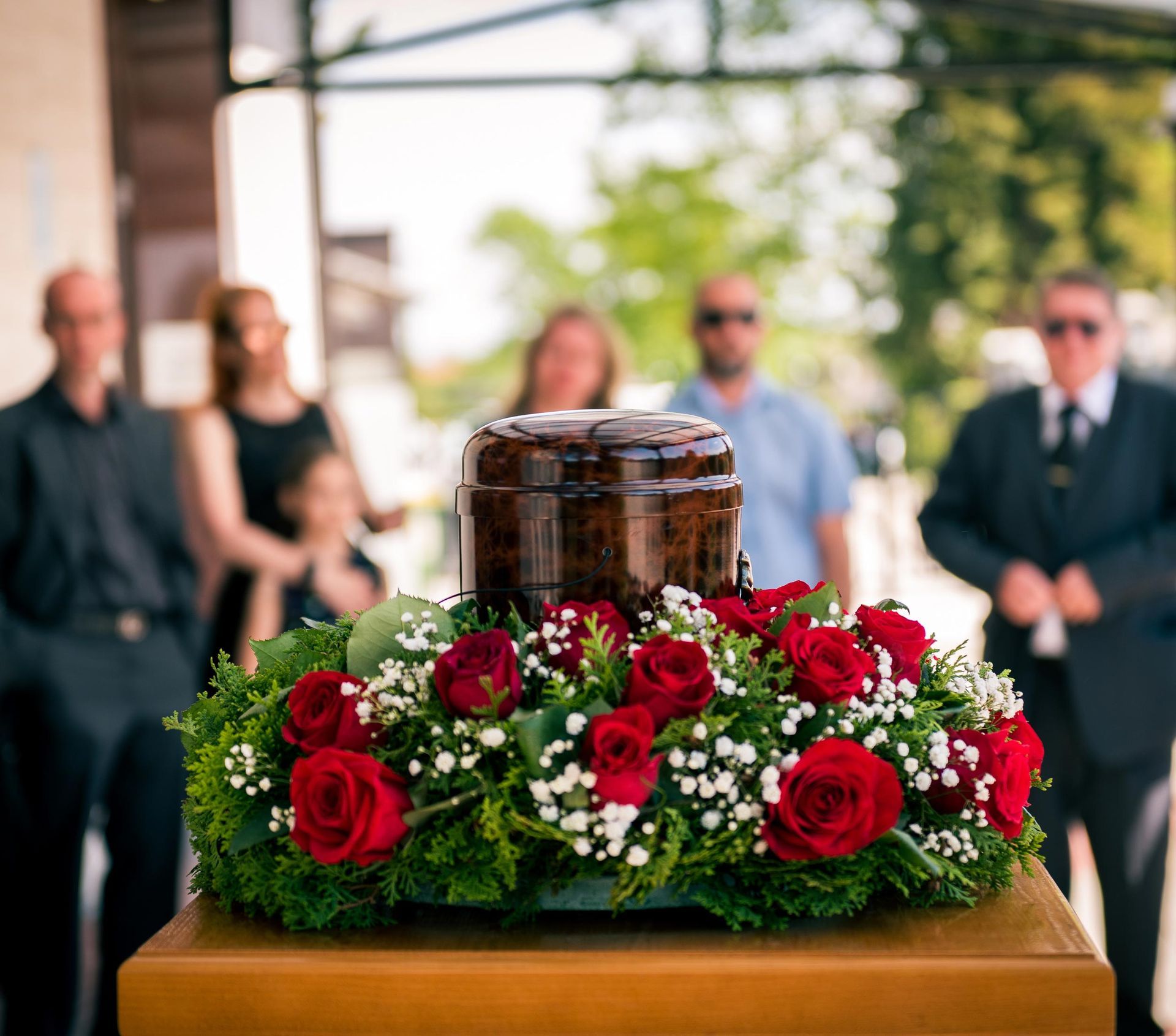 Urn with red rose wreath.
