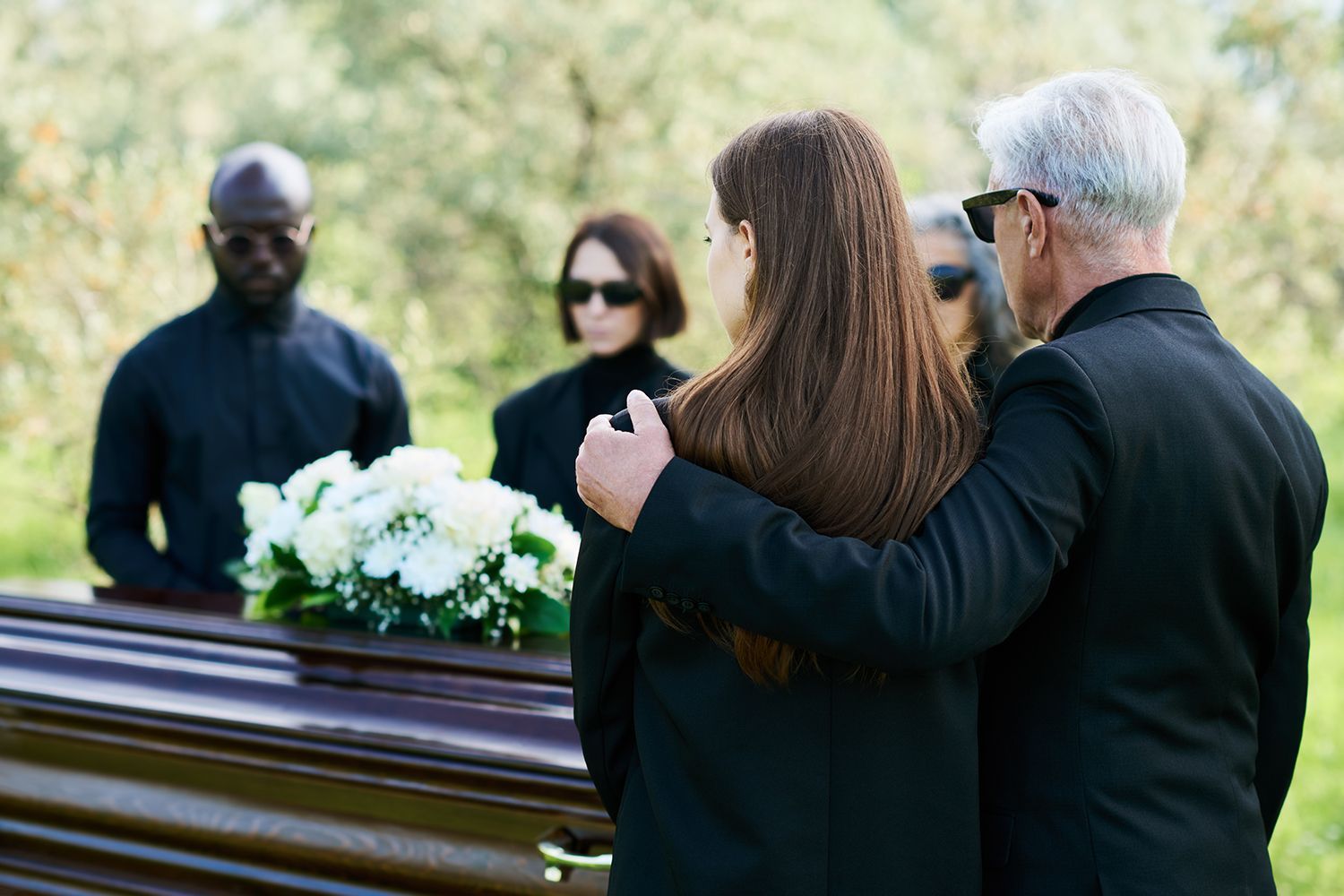 Mourners at a funeral casket.