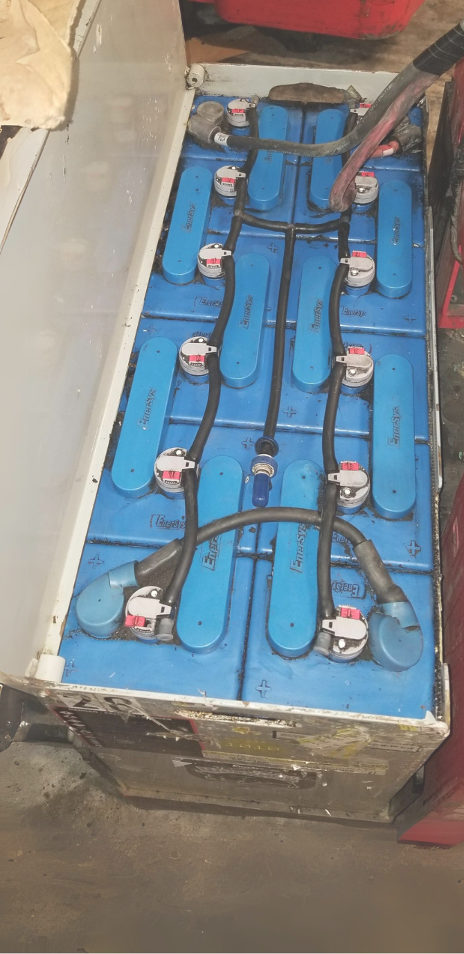 A bunch of blue batteries are sitting on top of each other on a table.
