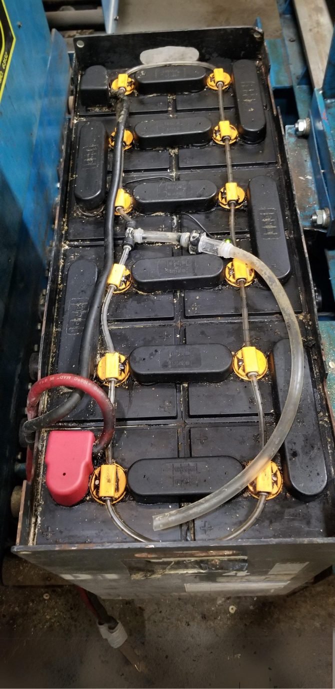 A close up of a battery with a hose attached to it.