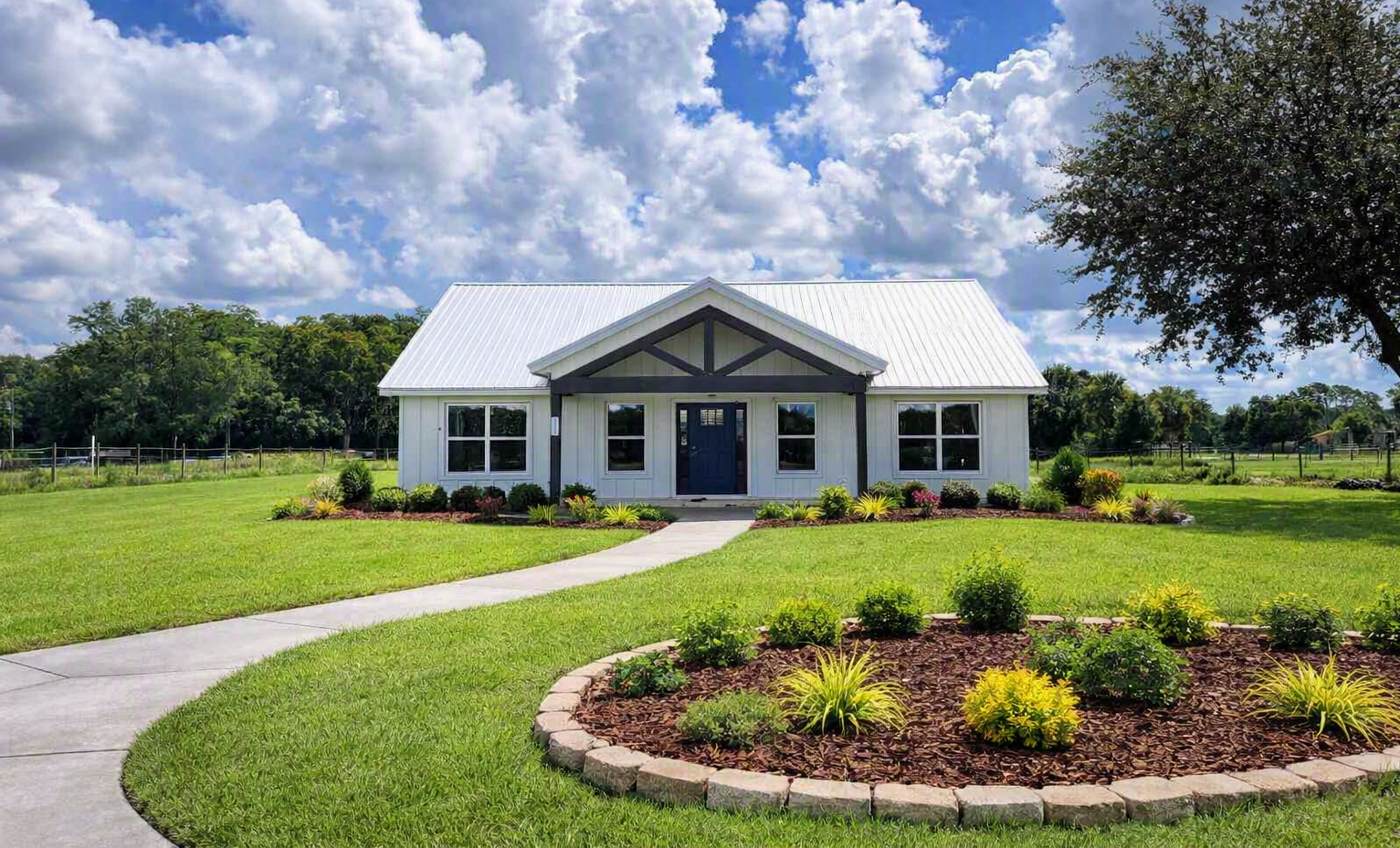 Single-story white house with gray roof, front walkway, and landscaped lawn under a blue sky