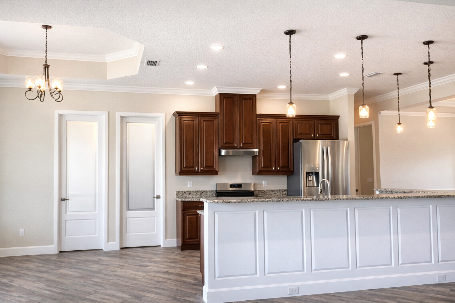 Modern kitchen with white island, wood cabinets, stainless appliances, and pendant lights