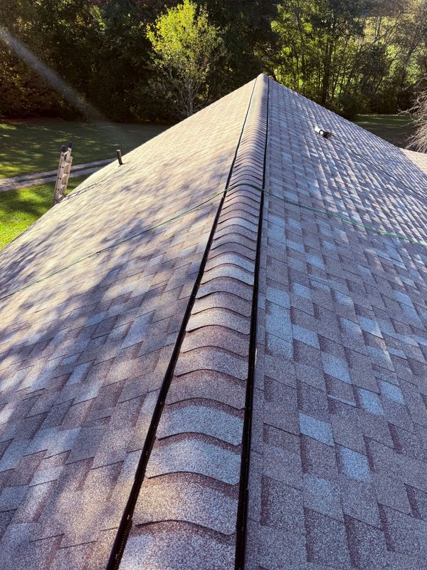 A construction worker on a roof, featuring a large rectangular opening exposing the wooden rafters below.