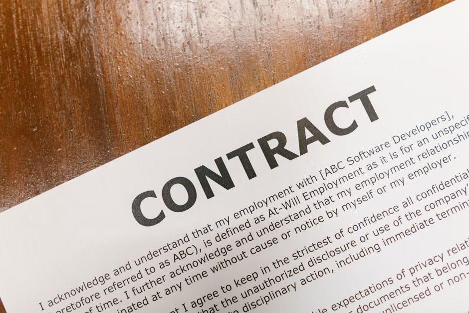 Business professionals reviewing a contract with a binding arbitration clause before signing, representing online dispute resolution.