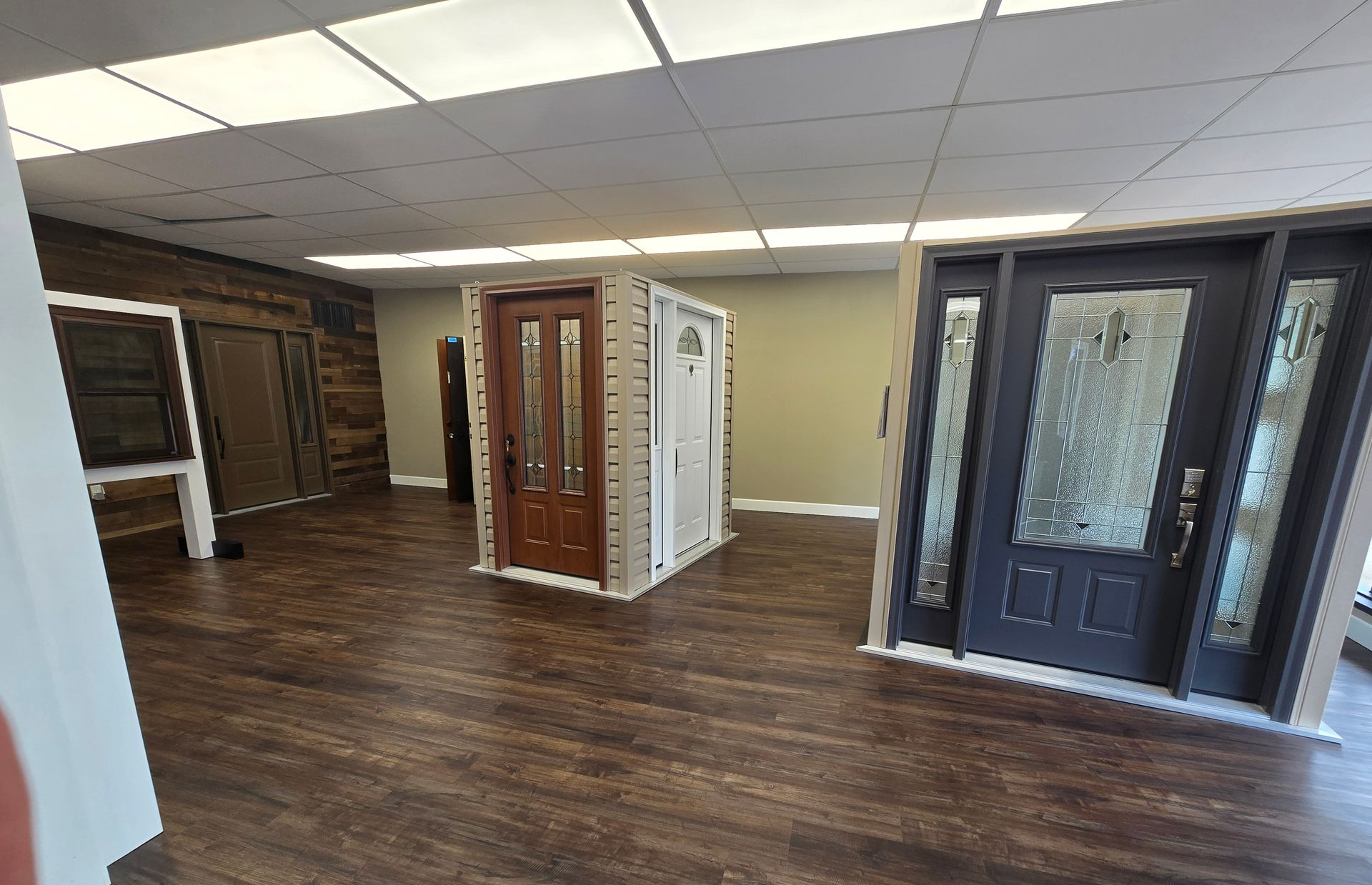 Showroom with interior doors in various styles and colors; wood floor, neutral walls.