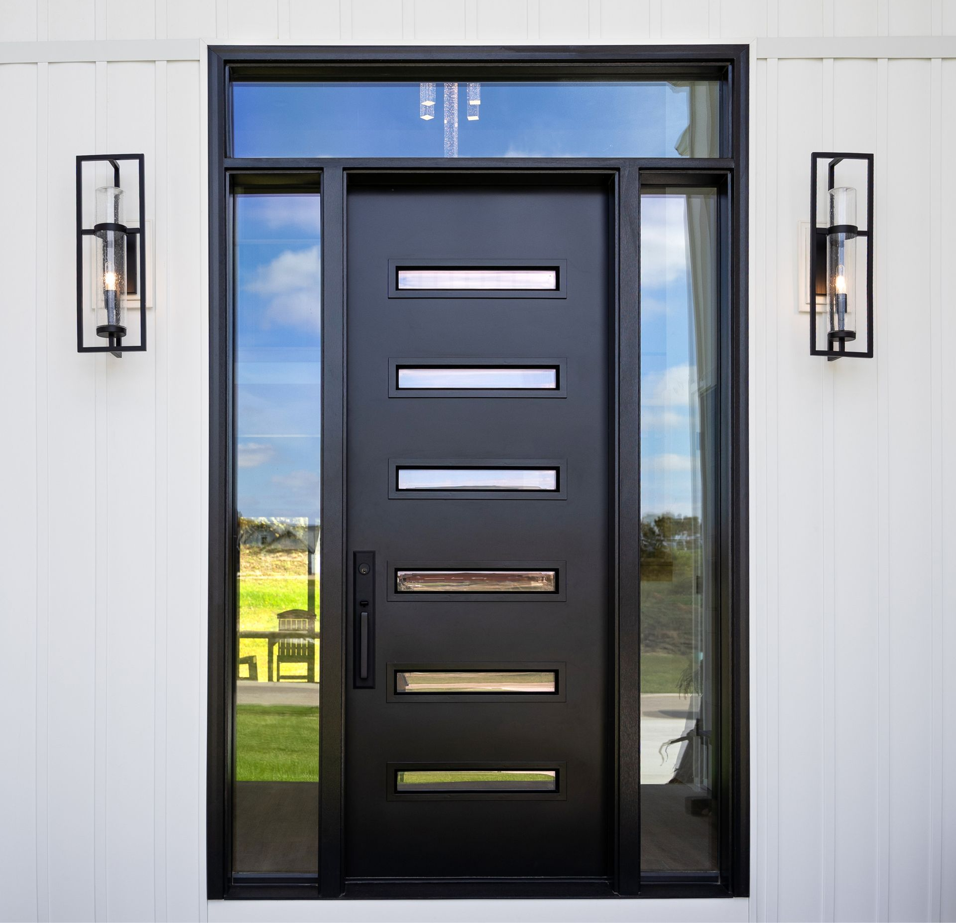 Black double entry doors with glass panels framed by porch decor and white rocking chairs. Black double entry doors with glass panels framed by porch decor and white rocking chairs.